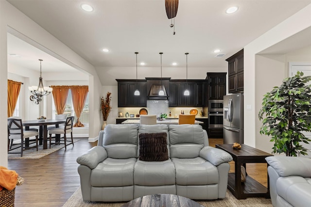 living room with recessed lighting, visible vents, wood finished floors, a chandelier, and baseboards