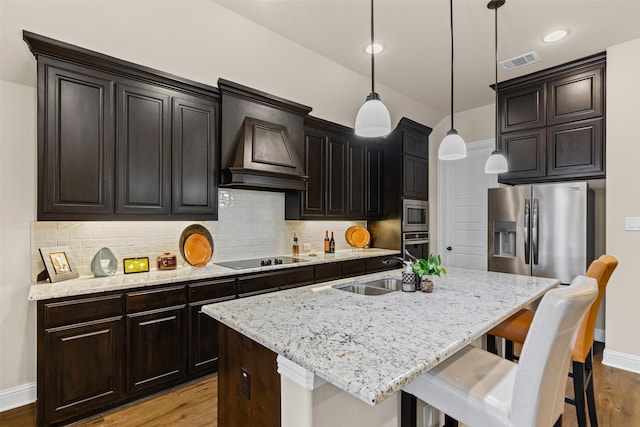 kitchen with stainless steel appliances, a sink, visible vents, and decorative backsplash