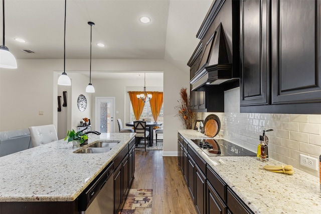 kitchen featuring black electric cooktop, wood finished floors, a sink, dishwasher, and custom range hood