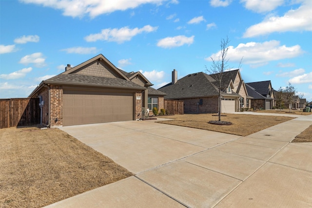 view of front facade featuring a garage, brick siding, fence, and driveway