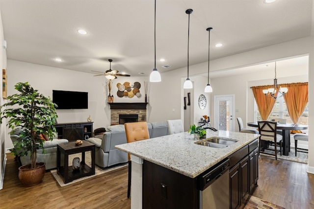 kitchen featuring dark wood-style floors, a fireplace, dishwasher, and a sink