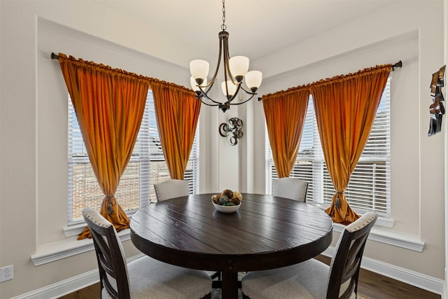 dining room featuring an inviting chandelier, dark wood-style floors, baseboards, and a wealth of natural light