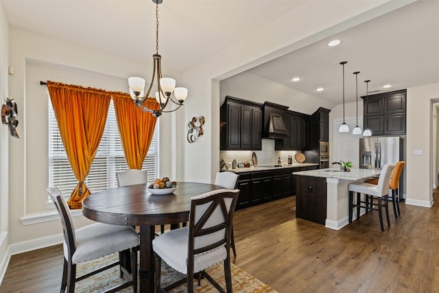 dining area featuring dark wood-type flooring, an inviting chandelier, recessed lighting, and baseboards