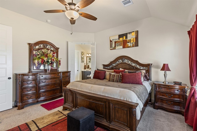 carpeted bedroom with a ceiling fan, visible vents, vaulted ceiling, and ensuite bathroom