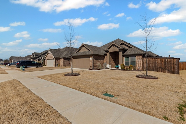 view of front facade featuring a shingled roof, brick siding, driveway, and an attached garage