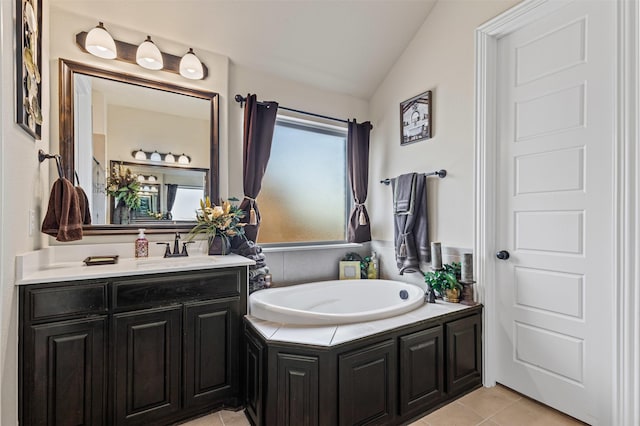 bathroom with lofted ceiling, a garden tub, tile patterned flooring, and vanity