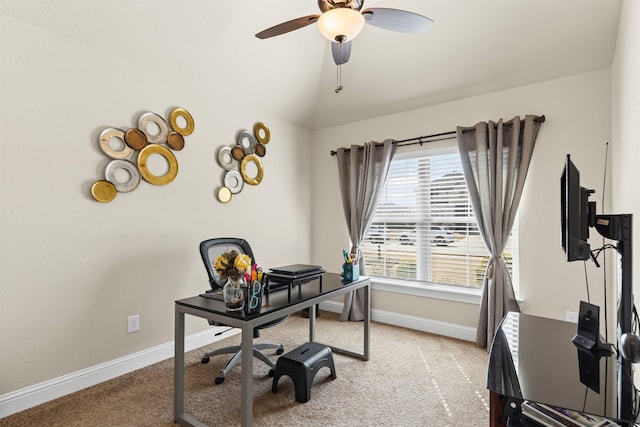 office space with baseboards, ceiling fan, vaulted ceiling, and light colored carpet