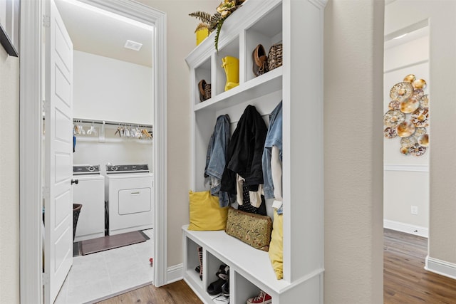 mudroom with independent washer and dryer, wood finished floors, visible vents, and baseboards