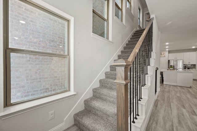 stairs featuring recessed lighting and wood finished floors