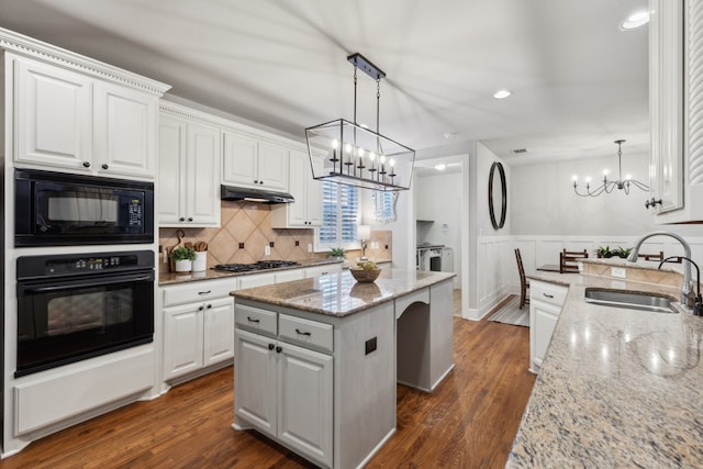 kitchen featuring dark wood-style flooring, white cabinetry, a sink, under cabinet range hood, and black appliances