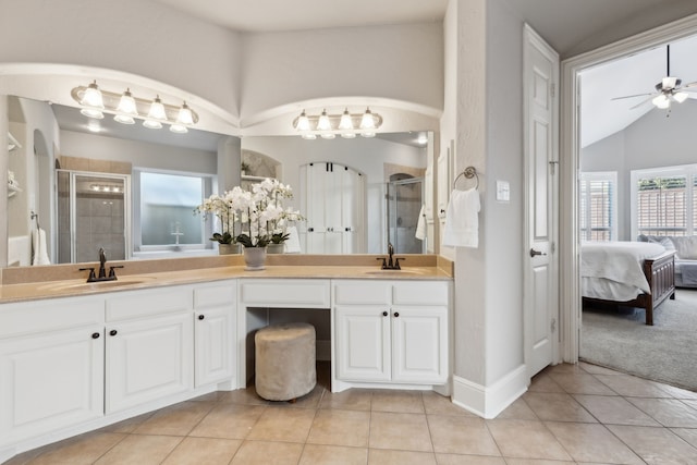 ensuite bathroom with a sink, a shower stall, and tile patterned floors