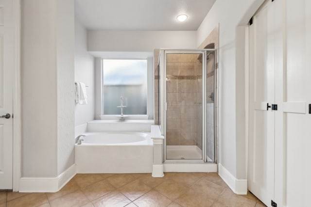 full bathroom with a garden tub, a shower stall, baseboards, and tile patterned floors