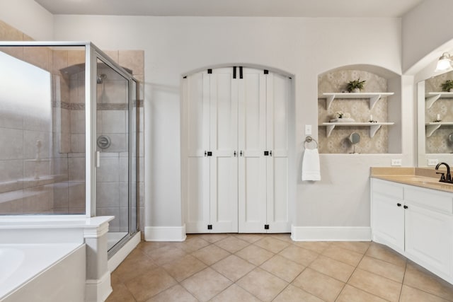 full bathroom with vanity, baseboards, a shower stall, a bath, and tile patterned floors