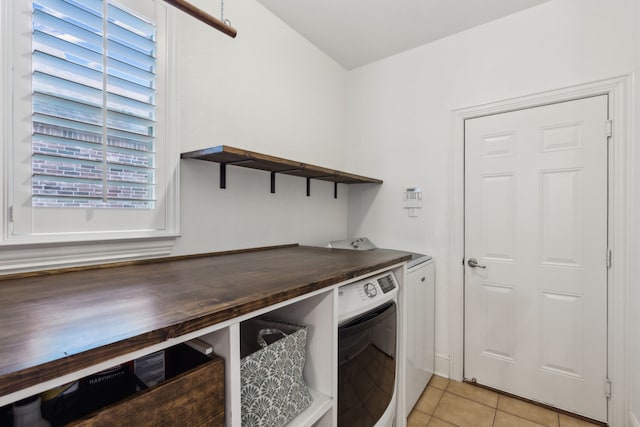 laundry room featuring washer and dryer, laundry area, and light tile patterned flooring