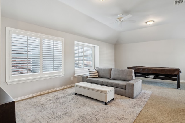 living area featuring lofted ceiling, visible vents, a ceiling fan, carpet flooring, and baseboards