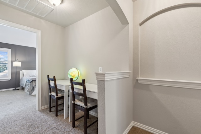 carpeted dining room with visible vents and baseboards