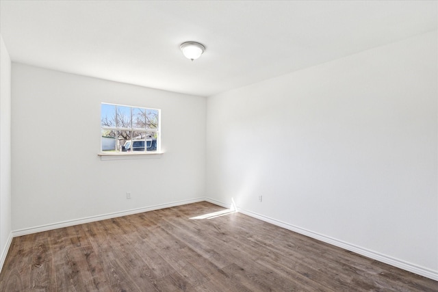 empty room featuring wood finished floors and baseboards