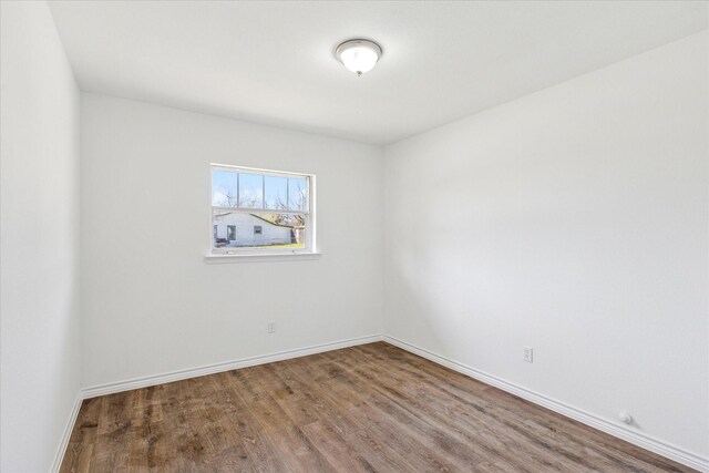 spare room with dark wood-style floors and baseboards