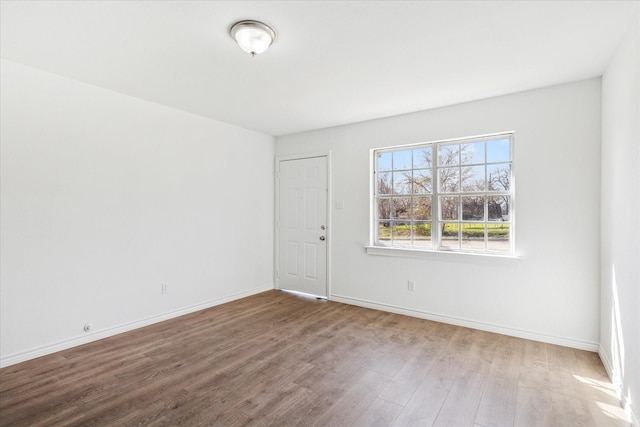 empty room featuring baseboards and wood finished floors