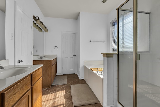 bathroom with a stall shower, two vanities, a sink, and a bath