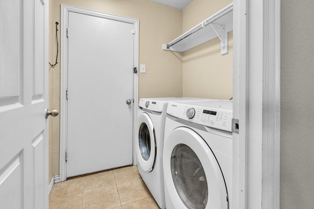 laundry area featuring laundry area, light tile patterned flooring, and washing machine and dryer