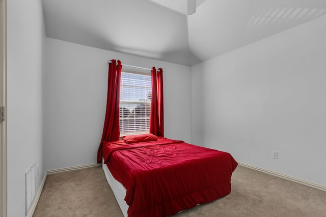 carpeted bedroom featuring vaulted ceiling, visible vents, and baseboards