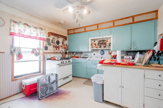 kitchen with light floors, blue cabinetry, light countertops, and white range with gas cooktop