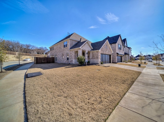 view of side of property featuring a yard, a residential view, brick siding, and fence