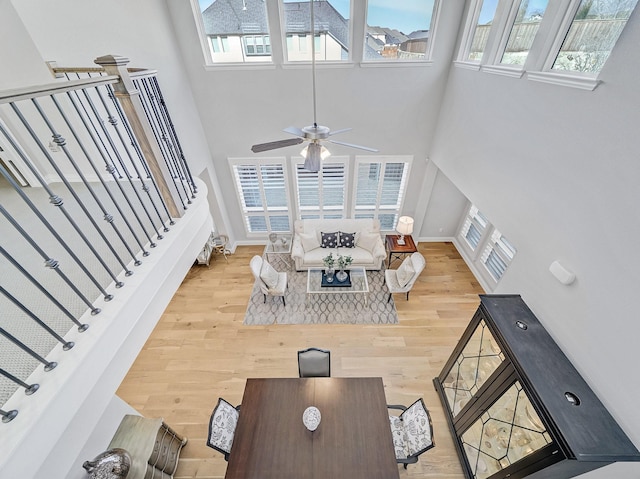 living room featuring a high ceiling, a wealth of natural light, and wood finished floors