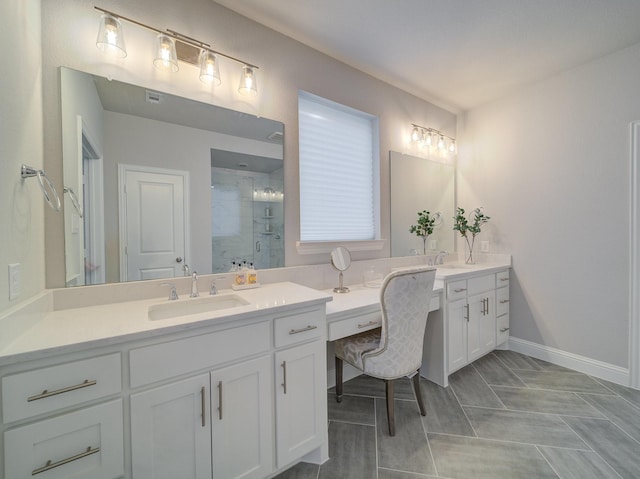 bathroom featuring a stall shower, baseboards, two vanities, and a sink