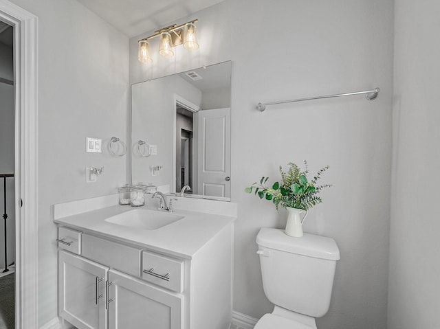 bathroom featuring toilet, visible vents, and vanity