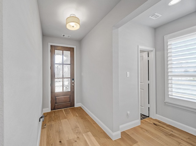 entryway featuring light wood finished floors, visible vents, and baseboards