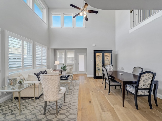 living area featuring a ceiling fan, light wood-style flooring, and baseboards