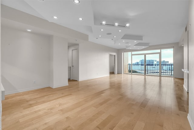 empty room with baseboards, recessed lighting, and light wood-style floors