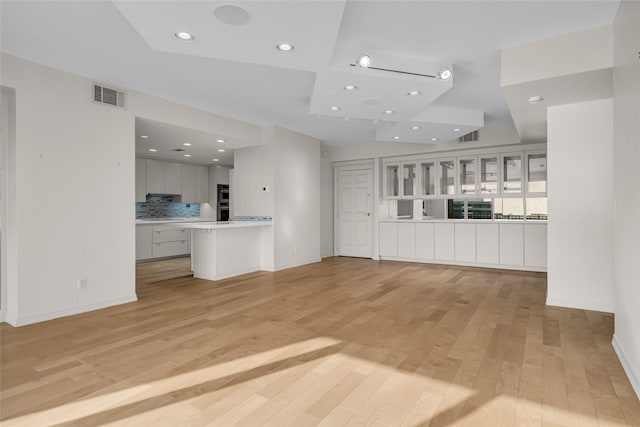 unfurnished living room featuring light wood-type flooring, visible vents, baseboards, and recessed lighting