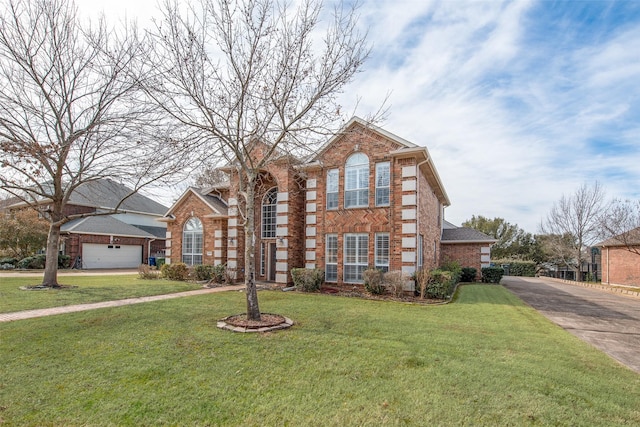 view of front of property featuring driveway, a chimney, a front lawn, and brick siding