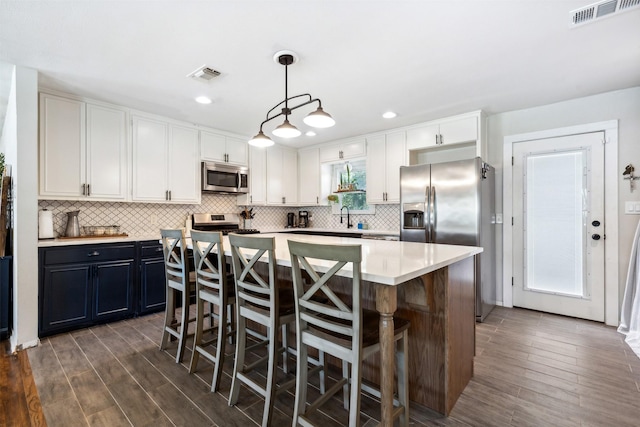 kitchen featuring visible vents, appliances with stainless steel finishes, and white cabinets