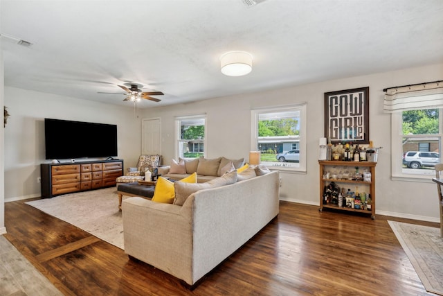 living room featuring a ceiling fan, visible vents, dark wood finished floors, and baseboards