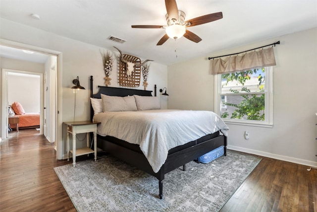 bedroom featuring hardwood / wood-style flooring, visible vents, baseboards, and a ceiling fan