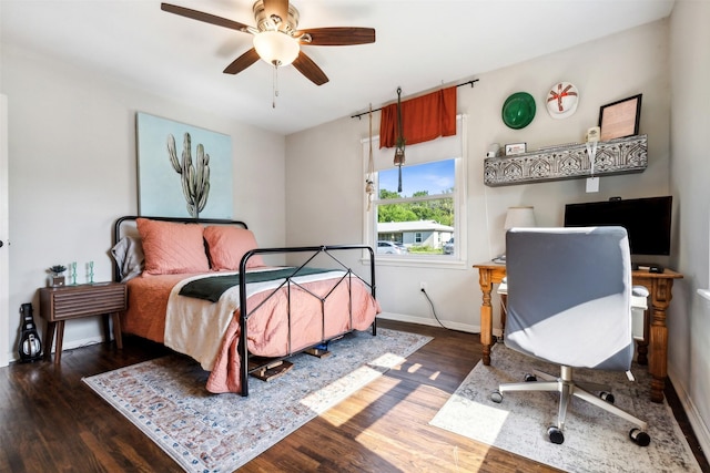 bedroom with a ceiling fan, baseboards, and wood finished floors