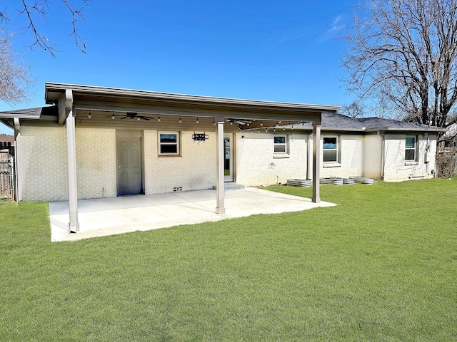 back of property featuring brick siding, a lawn, a patio, and ceiling fan