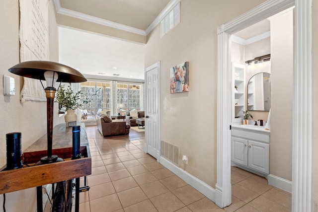 hallway featuring light tile patterned floors, ornamental molding, and visible vents