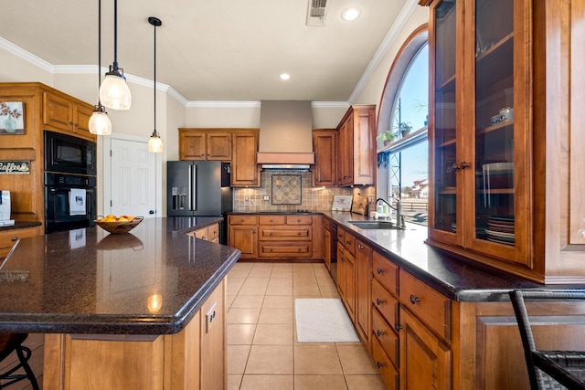 kitchen featuring visible vents, custom exhaust hood, a sink, black appliances, and brown cabinetry