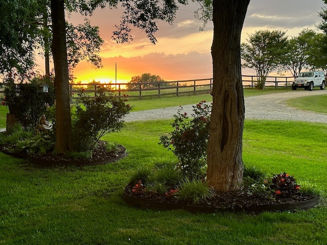 yard at dusk featuring fence