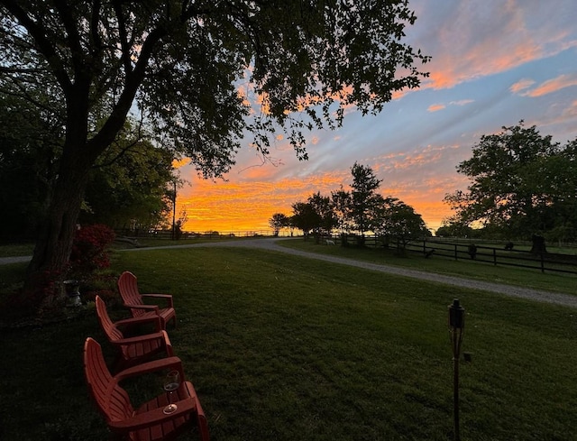 yard at dusk featuring fence and a rural view