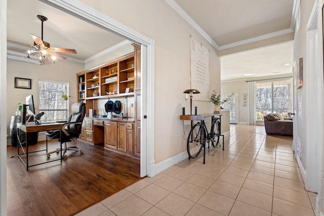 tiled office space with crown molding, baseboards, and ceiling fan