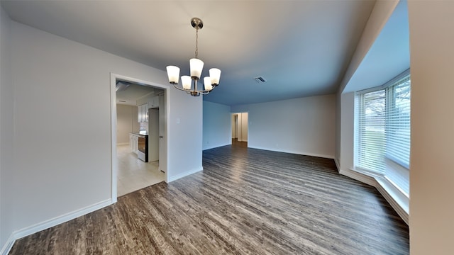 unfurnished dining area featuring an inviting chandelier, baseboards, visible vents, and dark wood-style flooring