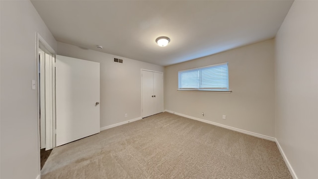 unfurnished bedroom featuring a closet, baseboards, visible vents, and carpet flooring