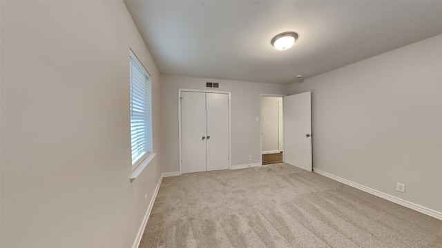 unfurnished bedroom featuring baseboards, a closet, visible vents, and carpet flooring