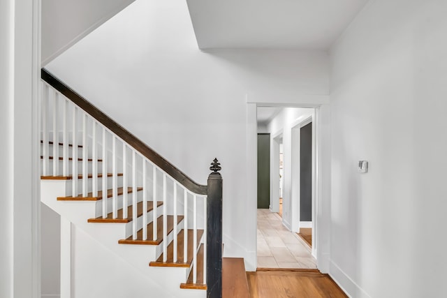 stairway with wood finished floors and baseboards